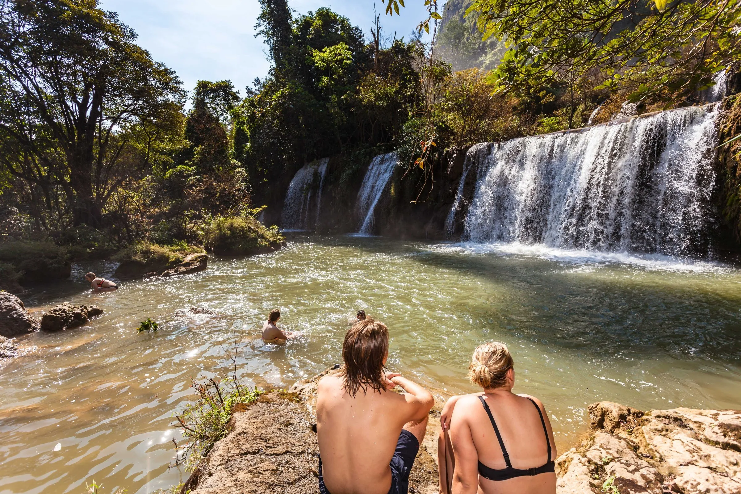 Travellers swimming in the pools beneath Thi Lor Su waterfall.