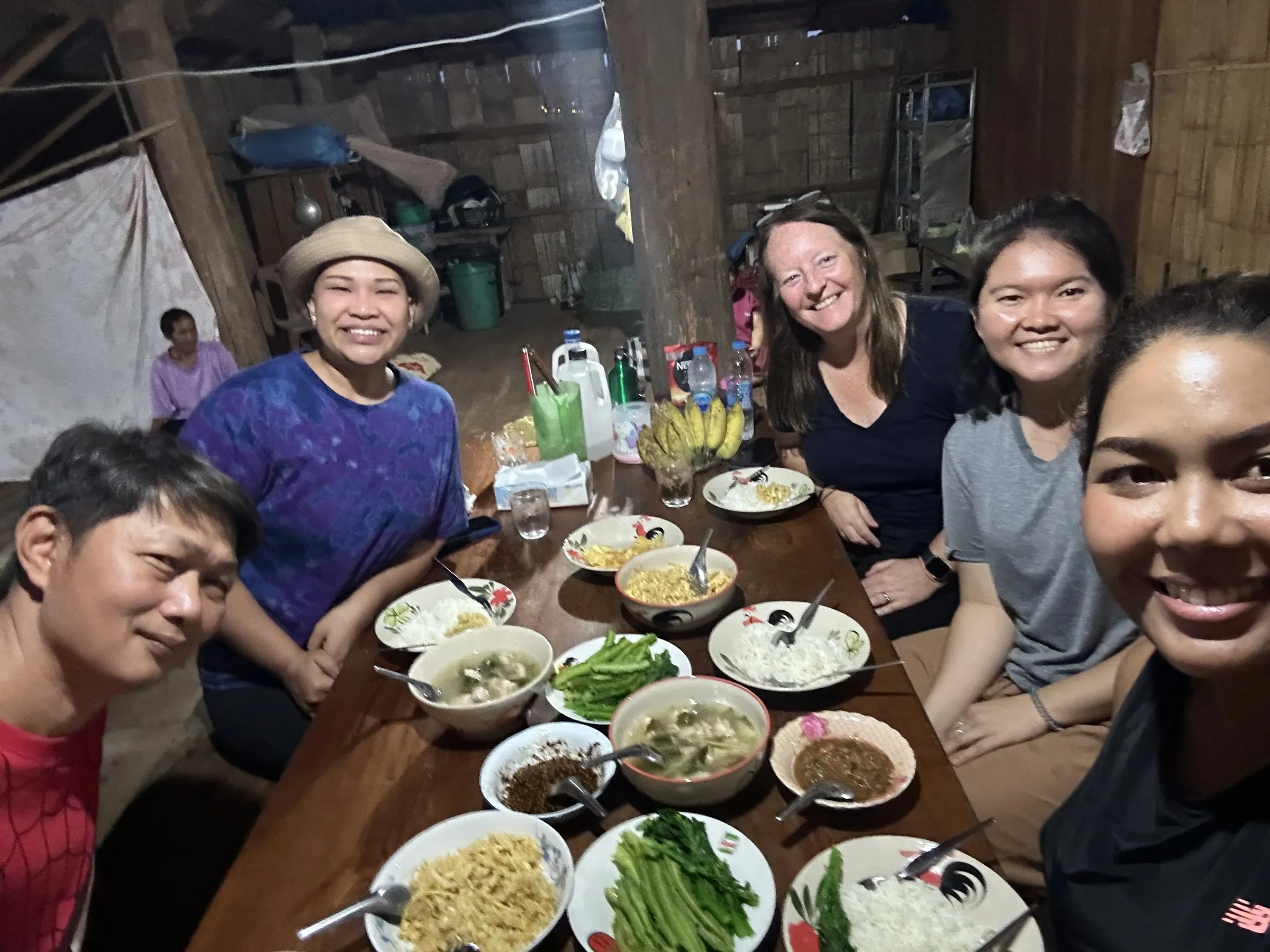 Travellers sharing a home-cooked dinner with their Karen host family at the homestay.